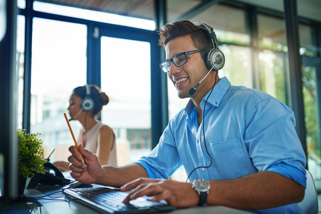 Shot of a young man working in a team of call center agents